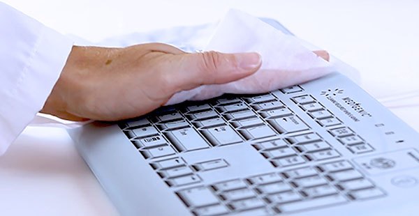 Hand wiping a Medigenic Essential infection control keyboard