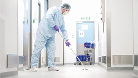 Operator mopping a pharmaceutical cleanroom corridor